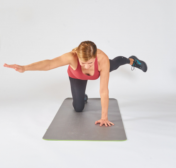 photo of a person performing the opposite arm and leg raise exercise, showing how to make it harder